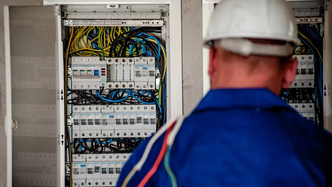 Preventive-Electrical-Maintenance Electrician inspecting circuit breaker panel.
