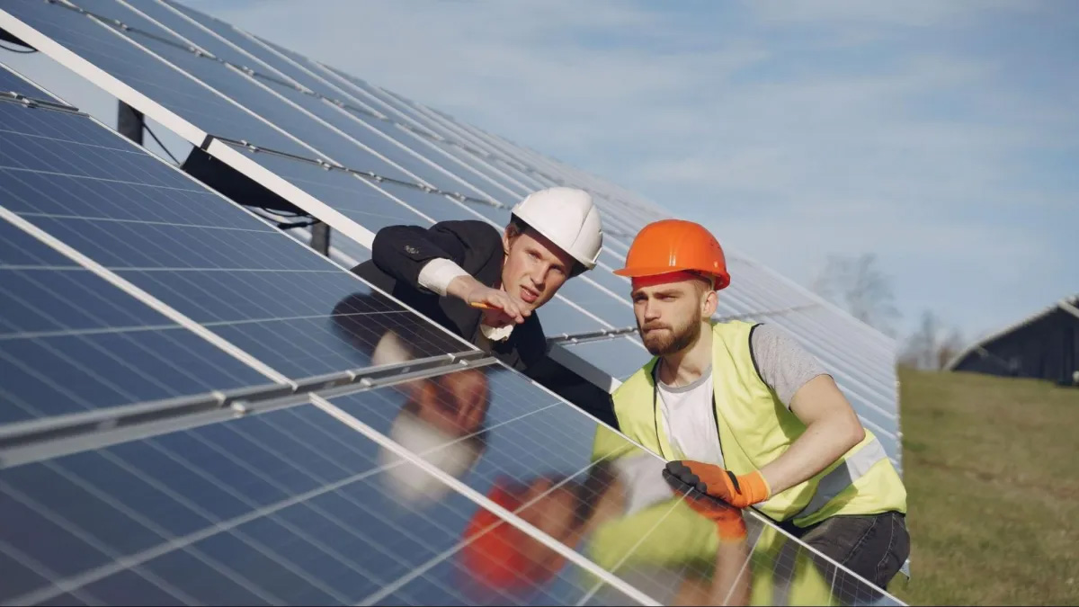 Professional-Electrical-Contractor Workers installing solar panels outdoors.