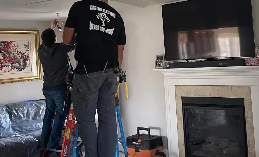 Stonehams-Best-Electricians Electricians installing ceiling light fixture.