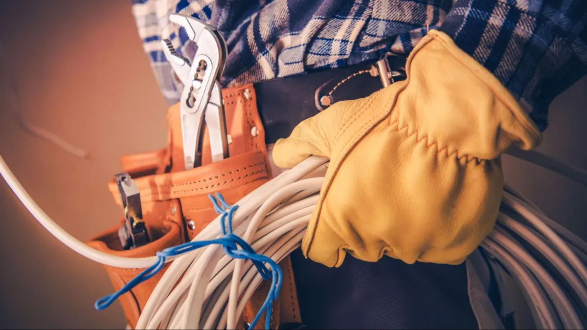 Electrician holding tools and wires.